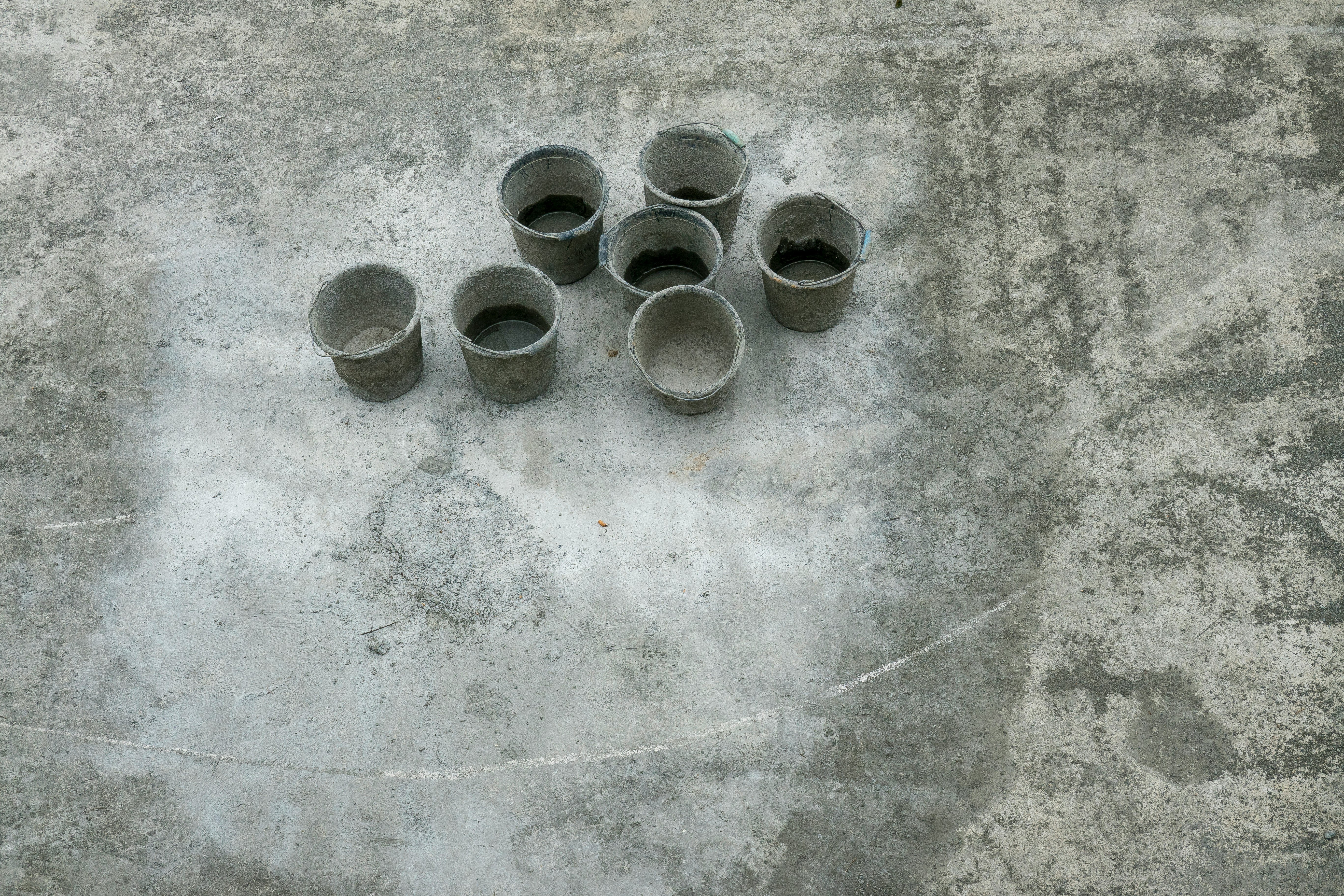 eight gray metal round containers on gray concrete floor